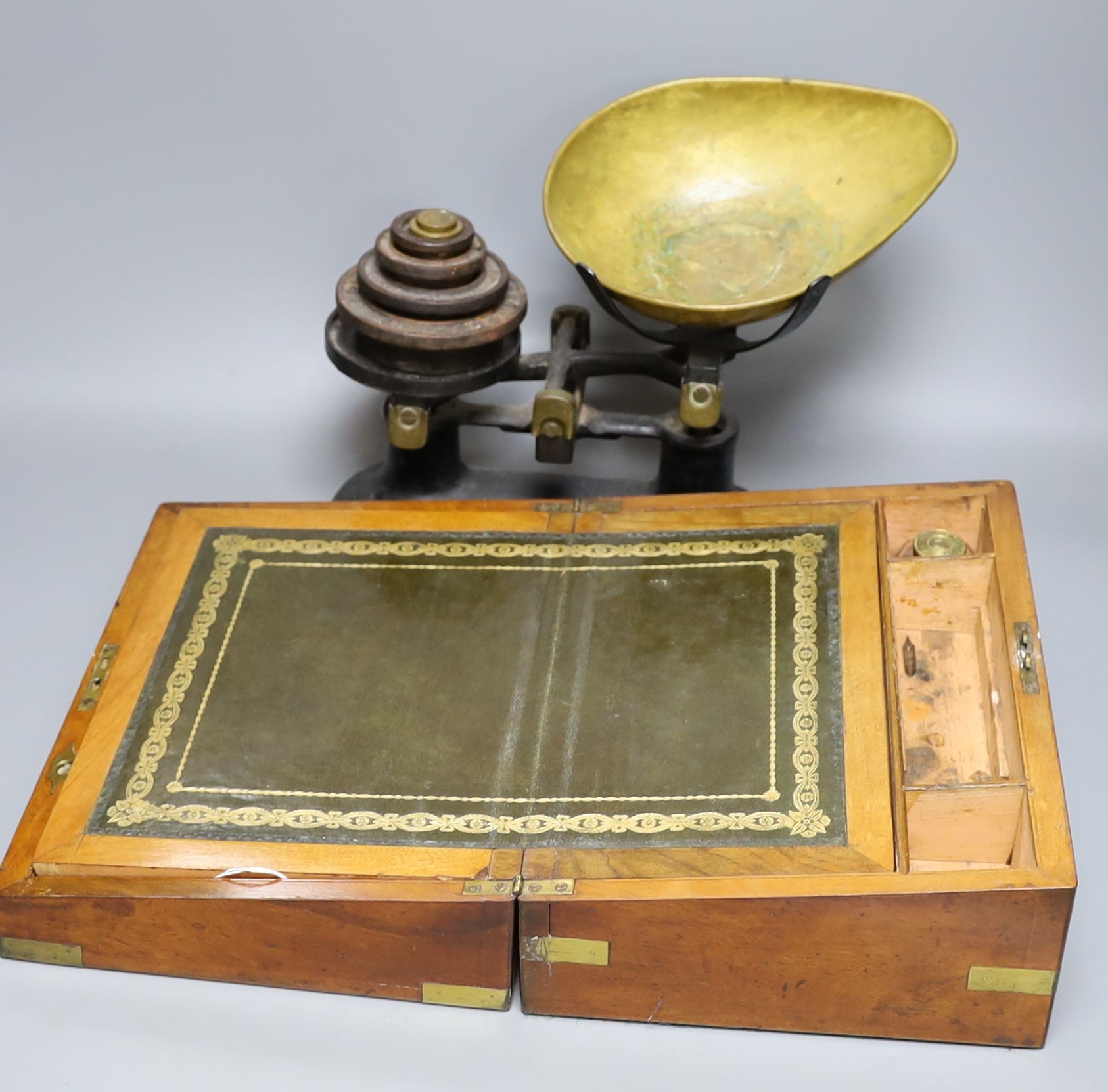 A Victorian walnut writing slope and a set of Victorian cast iron scales and weights (2), writing box 30 cms wide x14 cms high.